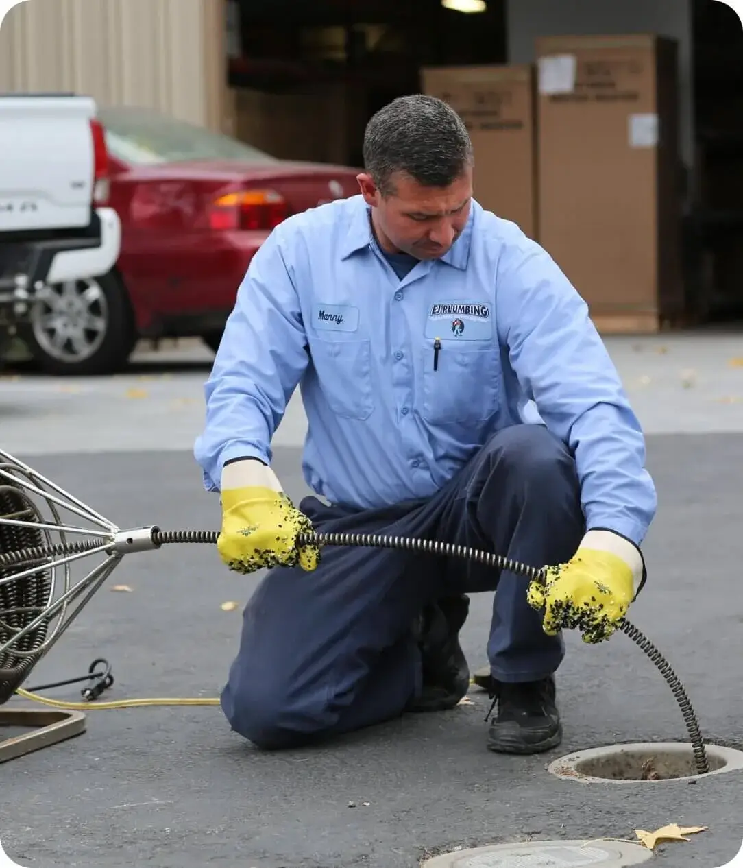 A BlueBoost plumber clears a sewer line with a drain cable